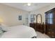 Bedroom featuring a ceiling fan, neutral walls, light wood floors, and a dark wood dresser with a mirror at 11007 Batello Dr, Venice, FL 34292