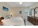 Bright bedroom featuring a ceiling fan, light wood floors, and a dark wood dresser with a mirror at 11007 Batello Dr, Venice, FL 34292