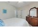 Bedroom with a ceiling fan, light wood floors, dark wood furniture, and a closet at 11007 Batello Dr, Venice, FL 34292