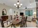 Formal dining room with elegant chandelier, views of the living area, and access to the lanai at 11007 Batello Dr, Venice, FL 34292