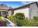 Landscaped home exterior featuring well-maintained hedges and manicured plants near the walkway at 11007 Batello Dr, Venice, FL 34292