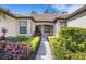 Inviting front entrance with a well-maintained walkway surrounded by vibrant, mature landscaping at 11007 Batello Dr, Venice, FL 34292