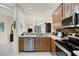 Well-equipped kitchen featuring stainless steel appliances, tile backsplash, and attractive wooden cabinetry at 11007 Batello Dr, Venice, FL 34292
