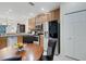 Open kitchen and dining area with stainless steel appliances, wood cabinets, and a round dining table at 11007 Batello Dr, Venice, FL 34292