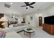 Bright living room featuring a comfortable sectional sofa, decorative pillows, and a ceiling fan at 11007 Batello Dr, Venice, FL 34292