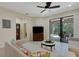 Cozy living room featuring neutral tones, a ceiling fan, and sliding glass doors to the lanai at 11007 Batello Dr, Venice, FL 34292