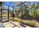 Enclosed patio with views of the lush garden and trees, offering a serene outdoor experience at 11007 Batello Dr, Venice, FL 34292