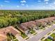 An aerial view of a villa with a tile roof, a paver driveway, a well-manicured lawn, and lush landscaping at 11096 Campazzo Dr, Venice, FL 34292