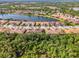 Aerial view of residential area featuring multiple single Gathering homes situated along a lake and surrounded by trees at 11096 Campazzo Dr, Venice, FL 34292