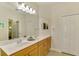 Bathroom featuring double sink vanity with wood cabinets, tiled floors, and large mirror at 11096 Campazzo Dr, Venice, FL 34292