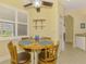 Cozy breakfast nook features a round table, four chairs, and bright natural light from the window at 11096 Campazzo Dr, Venice, FL 34292