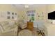 Cozy den with two comfortable armchairs, a writing desk, and nautical-themed decor at 11096 Campazzo Dr, Venice, FL 34292