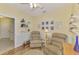 Sitting room features two comfortable armchairs, hardwood floors, and nautical-themed wall decor at 11096 Campazzo Dr, Venice, FL 34292