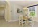 Bright dining room with a charming chandelier and seating for four near a window at 11096 Campazzo Dr, Venice, FL 34292