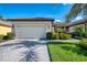 Beautiful villa with a paver driveway, tile roof, well-manicured lawn, and lush landscaping at 11096 Campazzo Dr, Venice, FL 34292