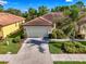 Beautiful villa with a paver driveway, tile roof, well-manicured lawn, and lush landscaping at 11096 Campazzo Dr, Venice, FL 34292