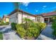 Beautiful villa with a paver driveway, tile roof, well-manicured lawn, and lush landscaping at 11096 Campazzo Dr, Venice, FL 34292