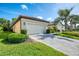 Beautiful villa with a paver driveway, tile roof, well-manicured lawn, and lush landscaping at 11096 Campazzo Dr, Venice, FL 34292