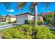 Beautiful villa with a paver driveway, tile roof, well-manicured lawn, and lush landscaping at 11096 Campazzo Dr, Venice, FL 34292