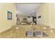 Granite kitchen counter showcasing a stainless sink with a view to the living area at 11096 Campazzo Dr, Venice, FL 34292