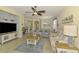 Open-concept living room features tile floors, neutral paint, ceiling fan, and flows into dining and kitchen at 11096 Campazzo Dr, Venice, FL 34292
