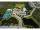 Aerial view featuring community amenities: a swimming pool, tennis courts, ball field, and lush landscaping at 11924 Tempest Harbor Loop, Venice, FL 34292