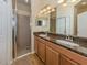 This bathroom features a double sink with granite countertop and tiled shower at 11924 Tempest Harbor Loop, Venice, FL 34292