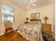 This bedroom features wood floors, tropical decor, a ceiling fan, and natural light at 11924 Tempest Harbor Loop, Venice, FL 34292