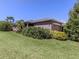 Well-maintained home exterior featuring a manicured lawn and vibrant landscaping at 11924 Tempest Harbor Loop, Venice, FL 34292