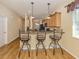 Kitchen bar with granite counters, wood cabinets, and stools at 11924 Tempest Harbor Loop, Venice, FL 34292