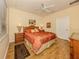 This main bedroom features a ceiling fan, wood floors, and a tropical-themed decor at 11924 Tempest Harbor Loop, Venice, FL 34292