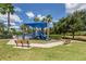 Community playground featuring blue play structures, picnic tables, benches and shade trees at 11924 Tempest Harbor Loop, Venice, FL 34292