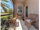 Screened porch featuring neutral chairs and a small side table at 11924 Tempest Harbor Loop, Venice, FL 34292