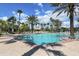 Large community swimming pool surrounded by palm trees, brick pavers and lounge chairs on a bright sunny day at 11924 Tempest Harbor Loop, Venice, FL 34292