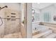 View of a bright bathroom featuring a tiled shower and a raised soaking tub with tile surround at 1500 Lemon Bay Dr, Venice, FL 34293