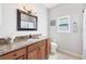 Bathroom with wood vanity, granite countertop, and decorative light fixture at 1500 Lemon Bay Dr, Venice, FL 34293