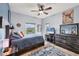 Bright bedroom features a ceiling fan, neutral walls, and large windows with a treeline view at 1500 Lemon Bay Dr, Venice, FL 34293