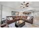 Comfortable living room with a large leather sectional, ceiling fan, and stylish decor at 1500 Lemon Bay Dr, Venice, FL 34293