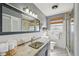 Well-lit bathroom with white tiled walls, decorative sink, and glass shower enclosure at 1537 Overbrook Rd, Englewood, FL 34223