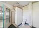 Bathroom featuring a toilet, open shower, and access door to the garage at 1537 Overbrook Rd, Englewood, FL 34223