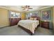 Cozy bedroom with wood furniture, soft carpet, ceiling fan, and two windows with natural light at 1537 Overbrook Rd, Englewood, FL 34223