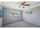 Bedroom featuring plush carpet, ceiling fan, neutral wall color, and natural light from two windows at 1537 Overbrook Rd, Englewood, FL 34223
