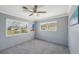 Well-lit bedroom with a ceiling fan, neutral carpet, two windows and freshly painted walls at 1537 Overbrook Rd, Englewood, FL 34223