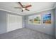 Bedroom with grey carpet, neutral paint and a double closet illuminated by natural light at 1537 Overbrook Rd, Englewood, FL 34223