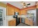 Kitchen with light wood cabinets, stainless steel appliances, a ceiling fan, and a window above the sink at 1537 Overbrook Rd, Englewood, FL 34223