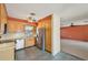 The kitchen has wood cabinets and stainless-steel appliances and is open to a living area with an exposed brick column at 1537 Overbrook Rd, Englewood, FL 34223