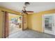 Bright living room with tile floors, a ceiling fan, and sliding doors to the outdoor patio and pool at 1537 Overbrook Rd, Englewood, FL 34223