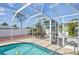 Relaxing screened-in pool with dining area, lush greenery, and ample space for entertaining at 1537 Overbrook Rd, Englewood, FL 34223