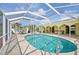 Large pool surrounded by lush landscaping, covered patio, and screened lanai for ultimate outdoor living at 1537 Overbrook Rd, Englewood, FL 34223