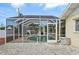 Enclosed screened pool area with a dining table and chairs and a table with an armchair at 1537 Overbrook Rd, Englewood, FL 34223